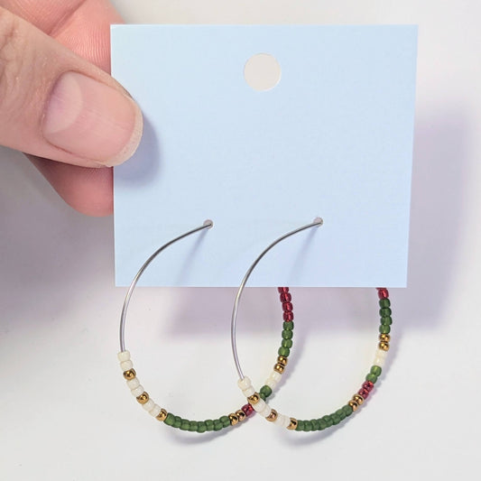 Hoop earrings with bead detailing on a card against a light background