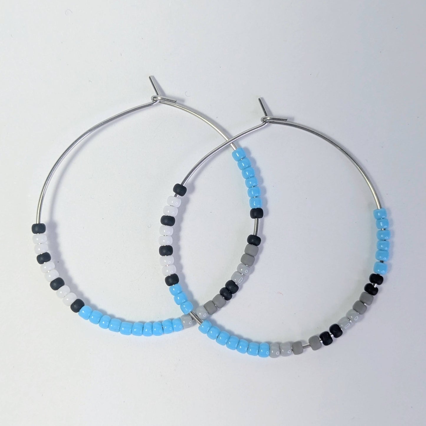 Hoop earrings with beaded detailing on a light gray background