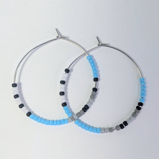 Hoop earrings with beaded detailing on a light gray background