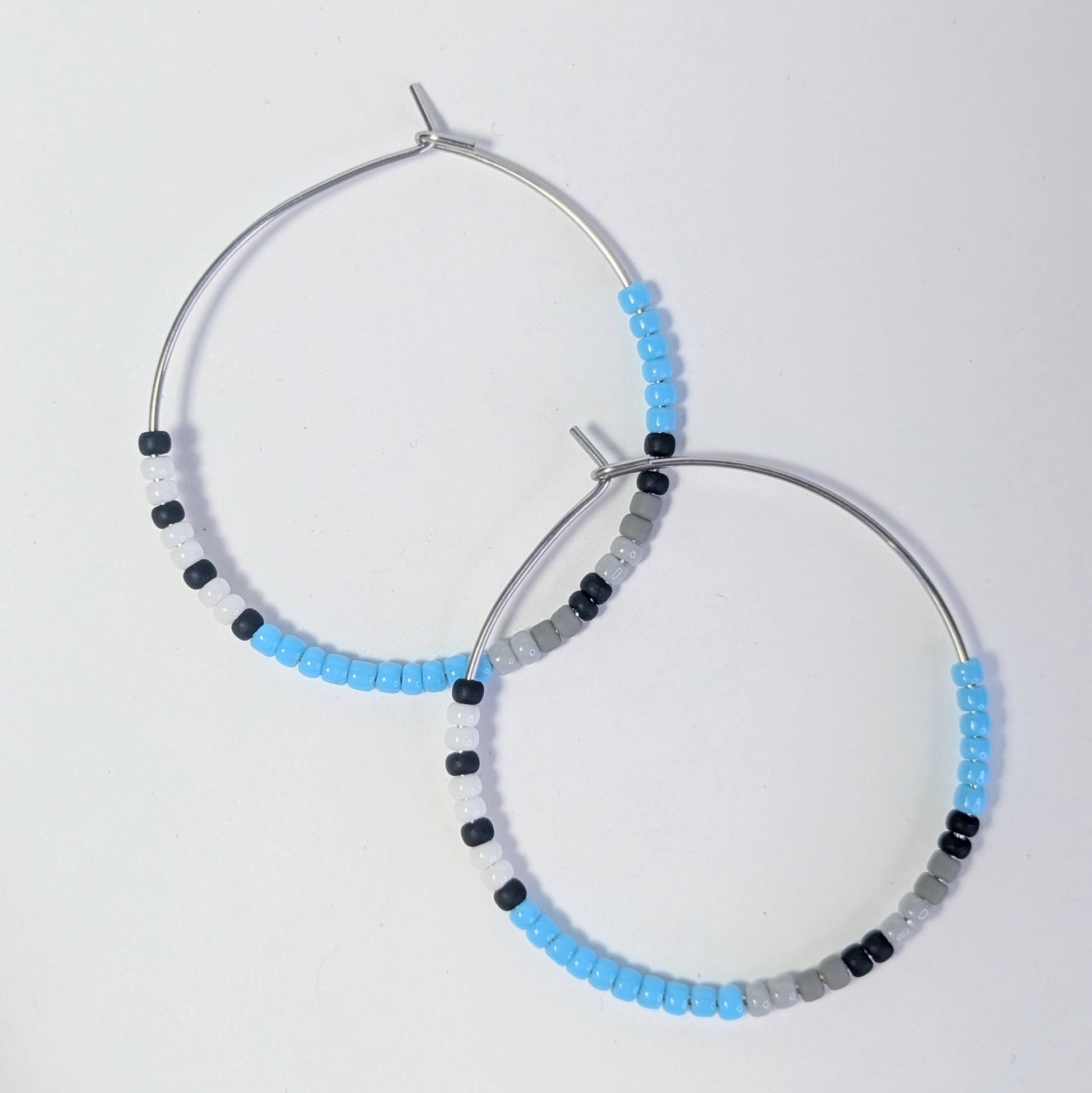 Pair of hoop earrings with beaded design on a light gray background