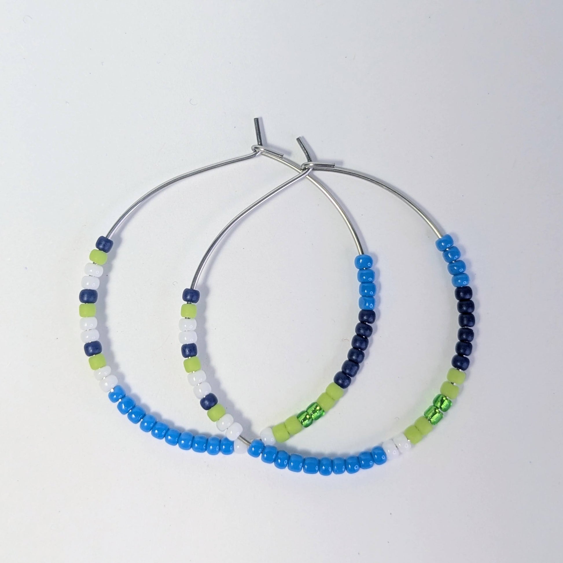 Pair of beaded hoop earrings on a light gray background