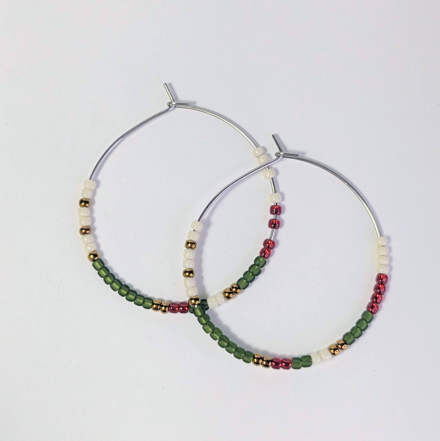 Pair of hoop earrings with beads on a light gray background