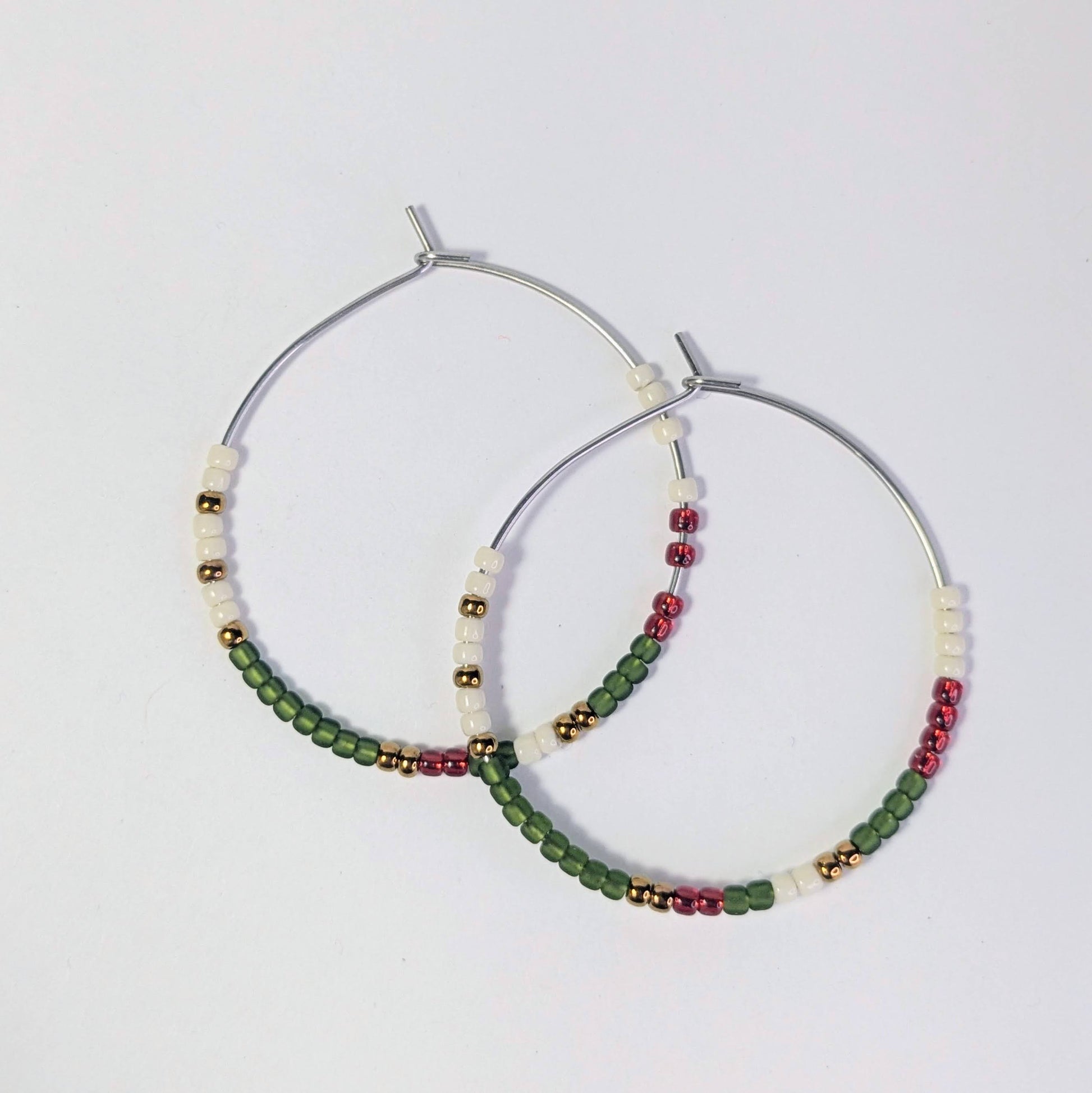 Pair of hoop earrings with beads on a light gray background