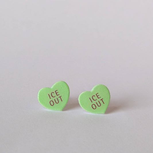 Green heart-shaped earrings with 'ICE OUT' text on a light gray background