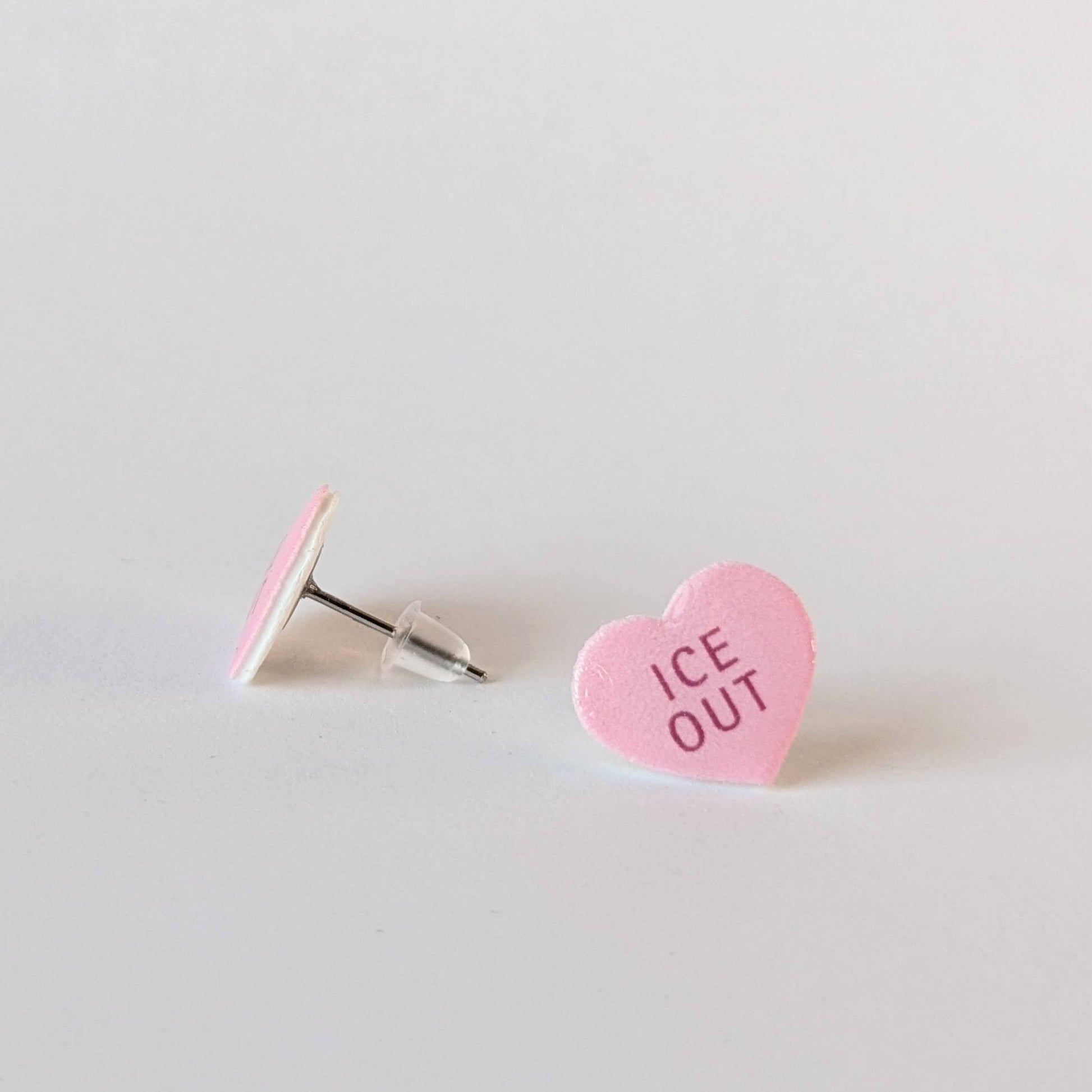 Heart-shaped pink candy with 'ICE OUT' text on a light gray background