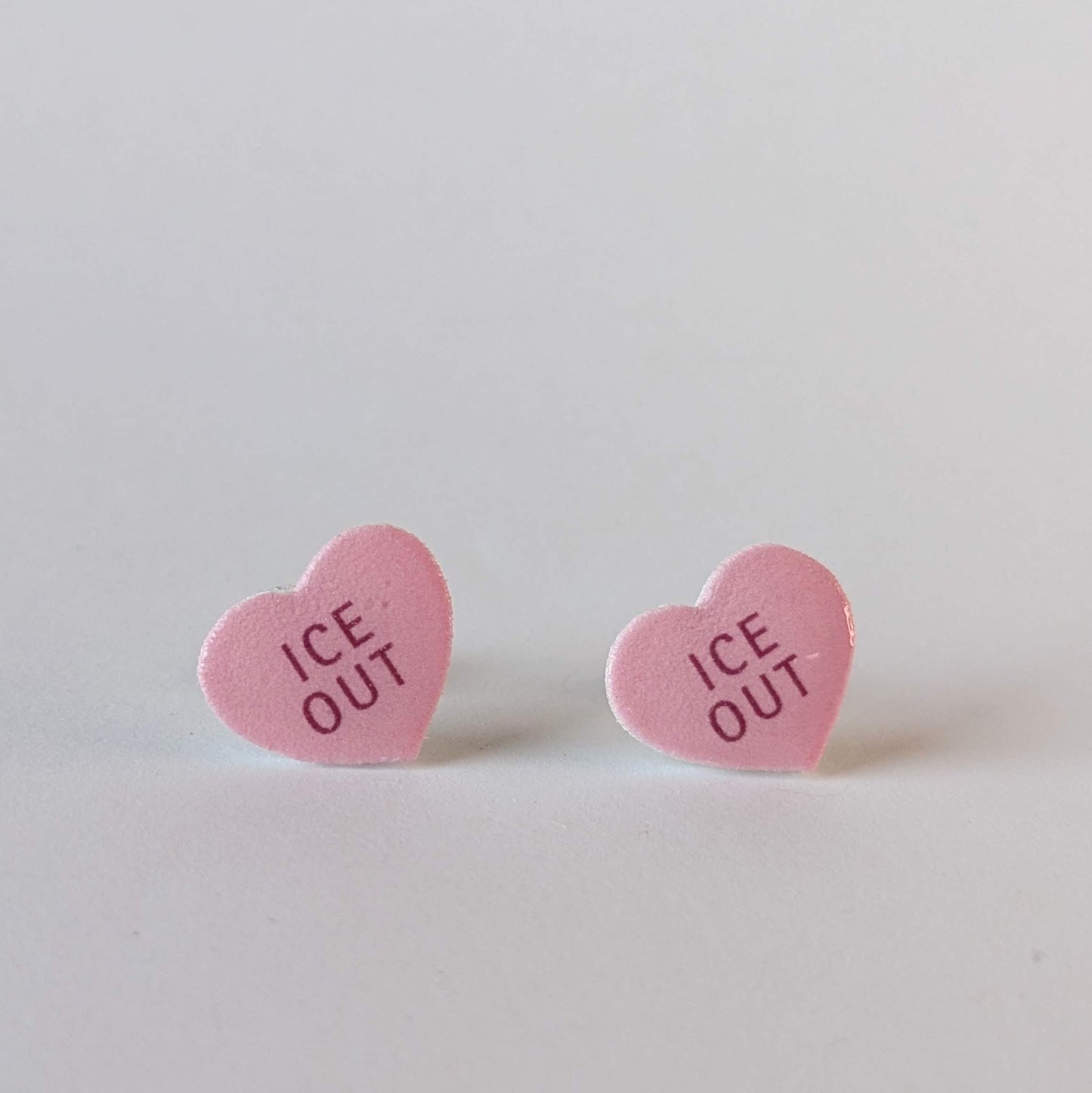 Heart-shaped pink earrings with 'ICE OUT' text.