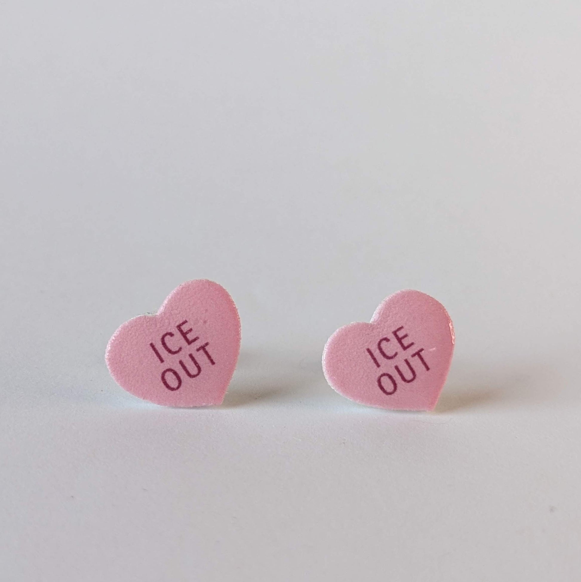 Heart-shaped pink earrings with 'ICE OUT' text.