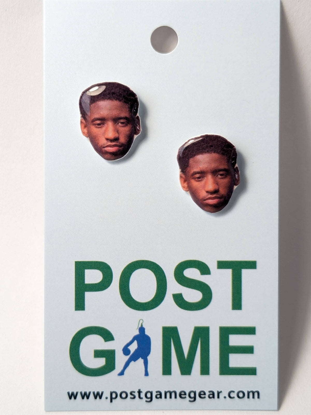 Two cutouts of a man's face (Jordan Addison) printed on oval shaped earrings. Earrings are displayed on a small card with the text Post Game and the website www.postgamegear.com