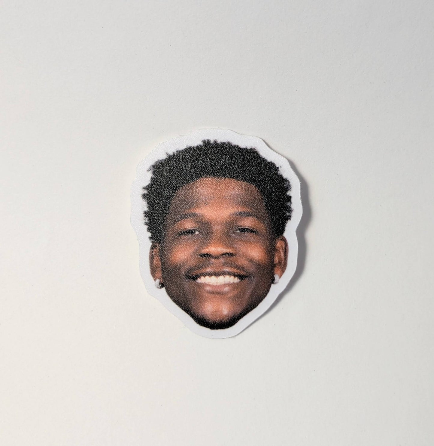 Sticker with a smiling person's face on a plain background