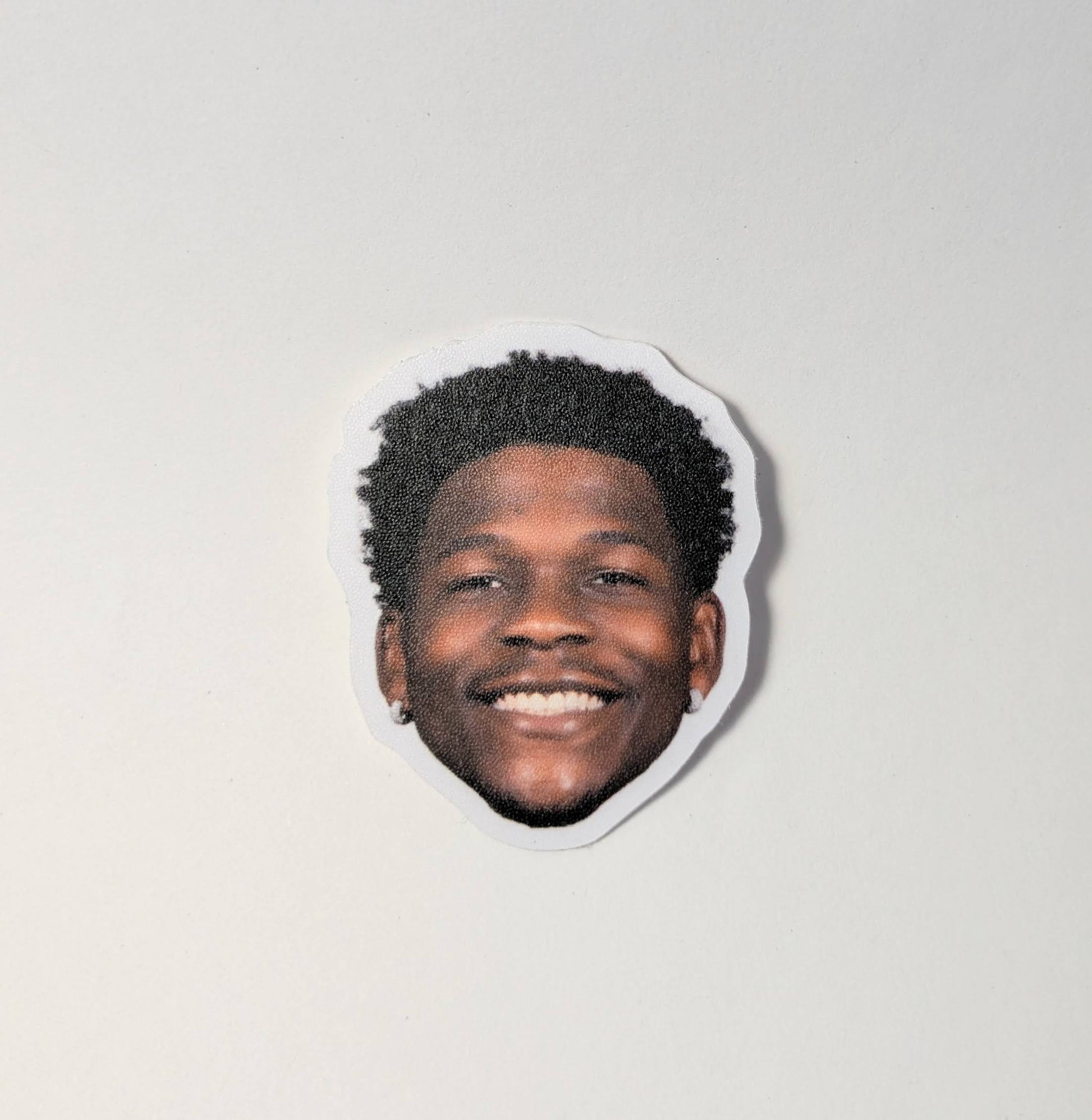 Sticker with a smiling person's face on a plain background