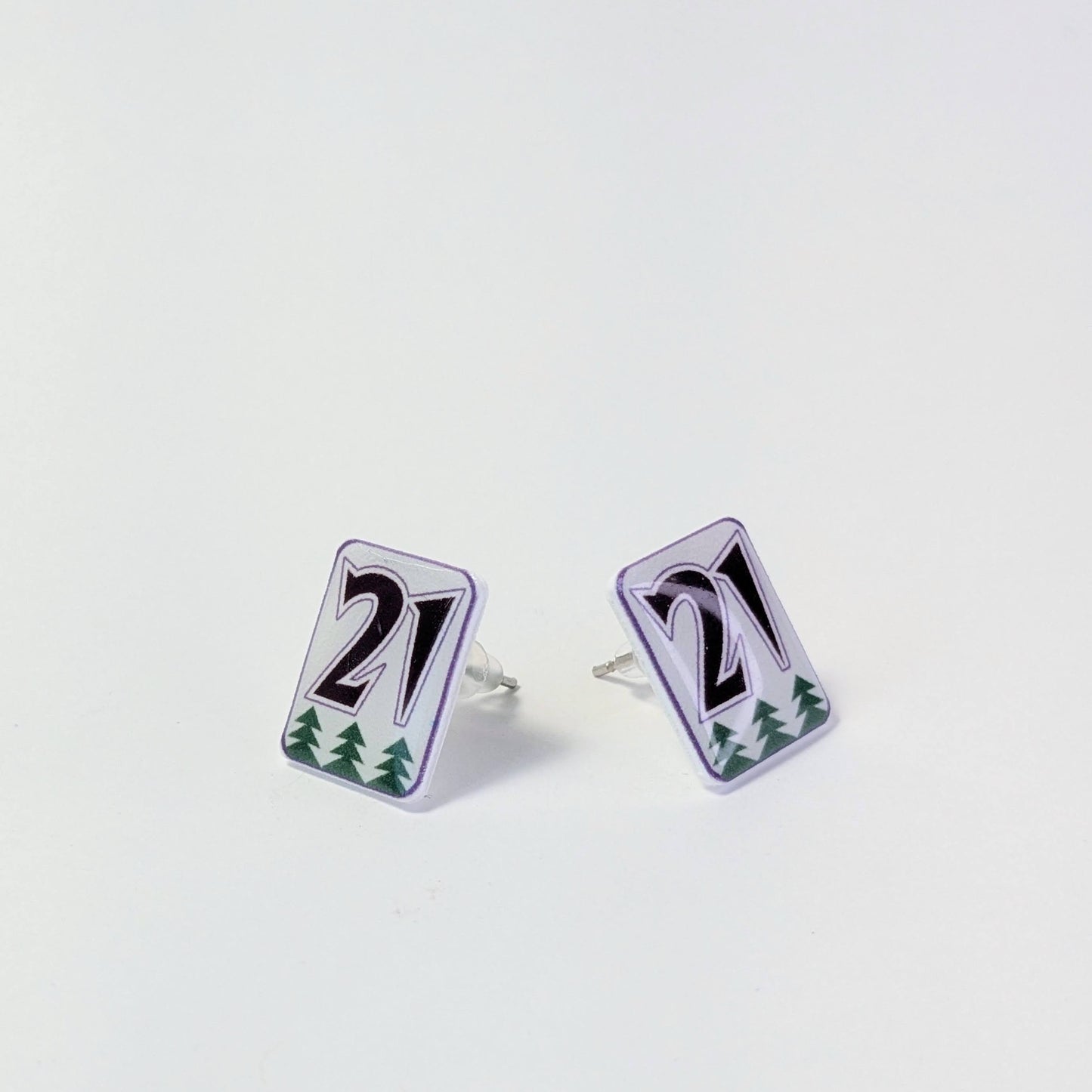 Pair of earrings with number '21' design on a light gray background