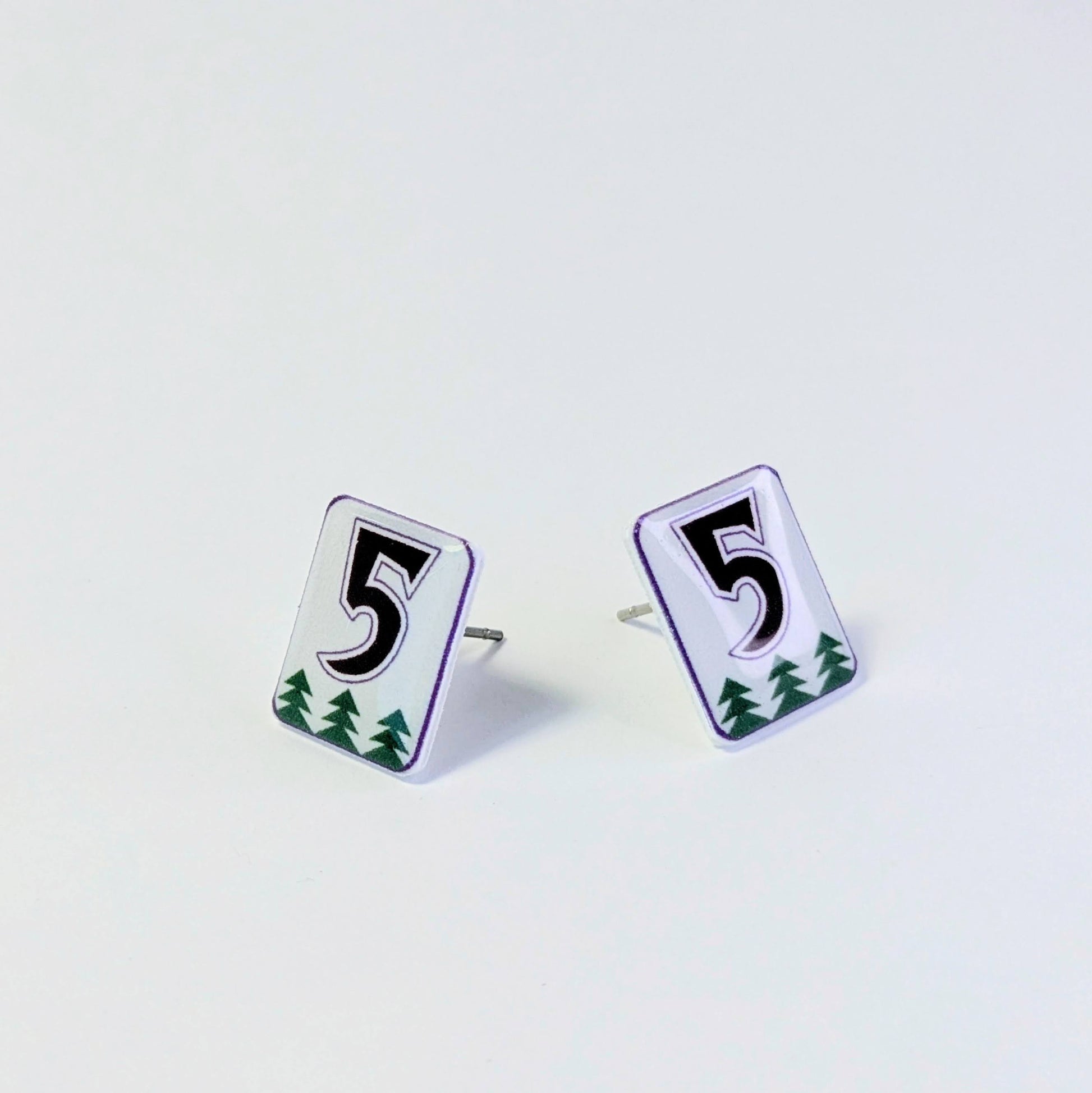 Pair of earrings with number 5 design on a light gray background