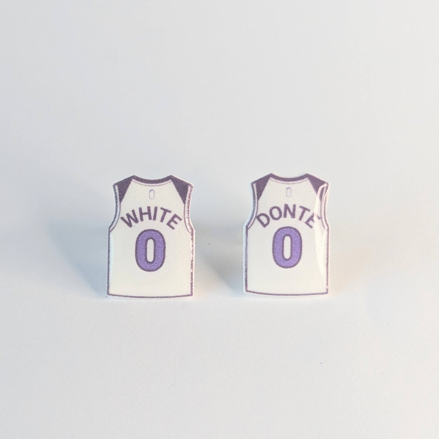Two basketball jersey earrings with White Donte over number 0 on a light gray background,