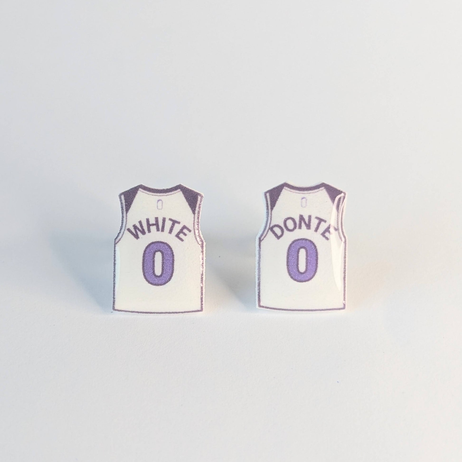 Two basketball jersey earrings with White Donte over number 0 on a light gray background,