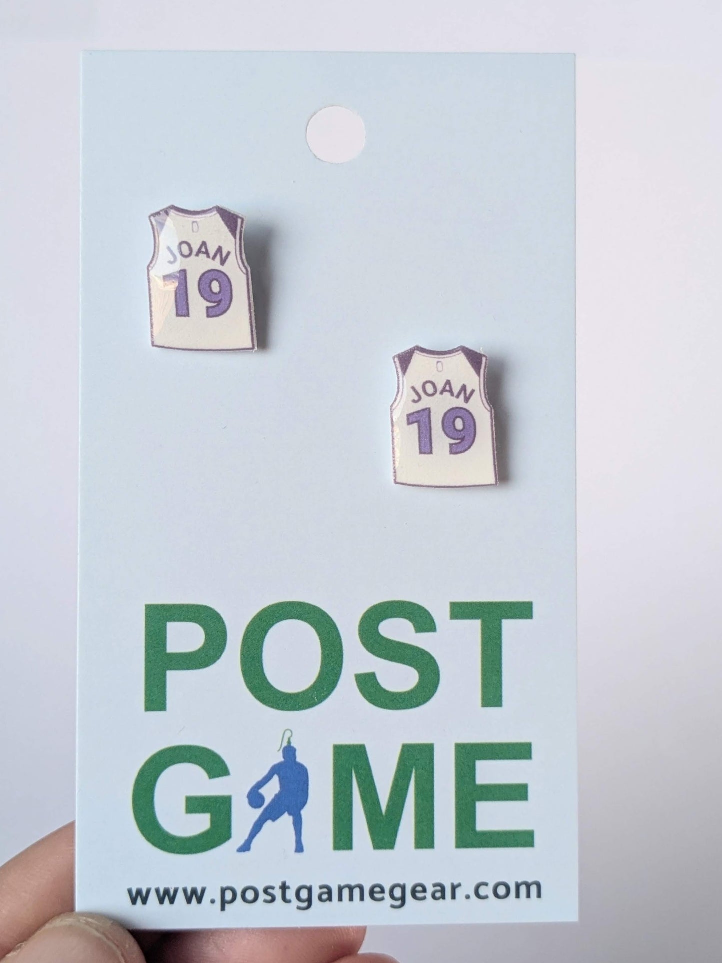 Pair of earrings resembling sports jerseys on a 'Post Game' branded card.