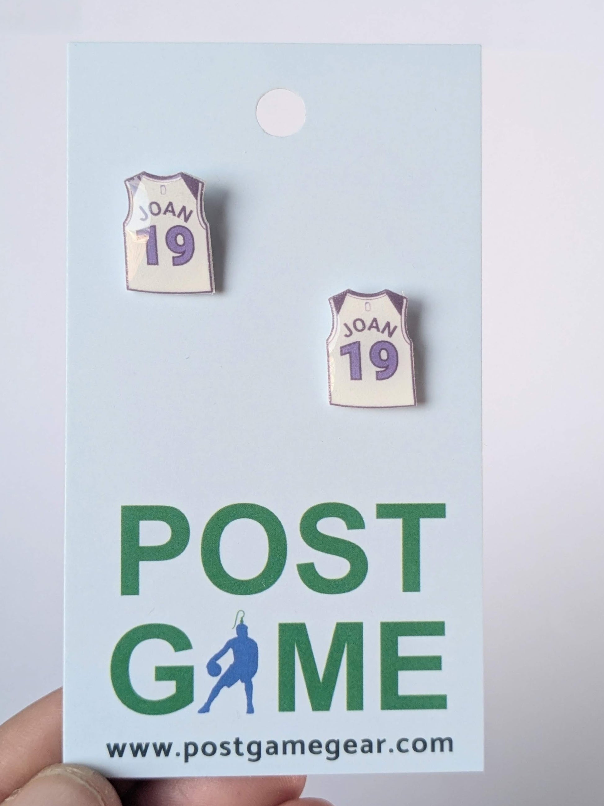 Pair of earrings resembling sports jerseys on a 'Post Game' branded card.
