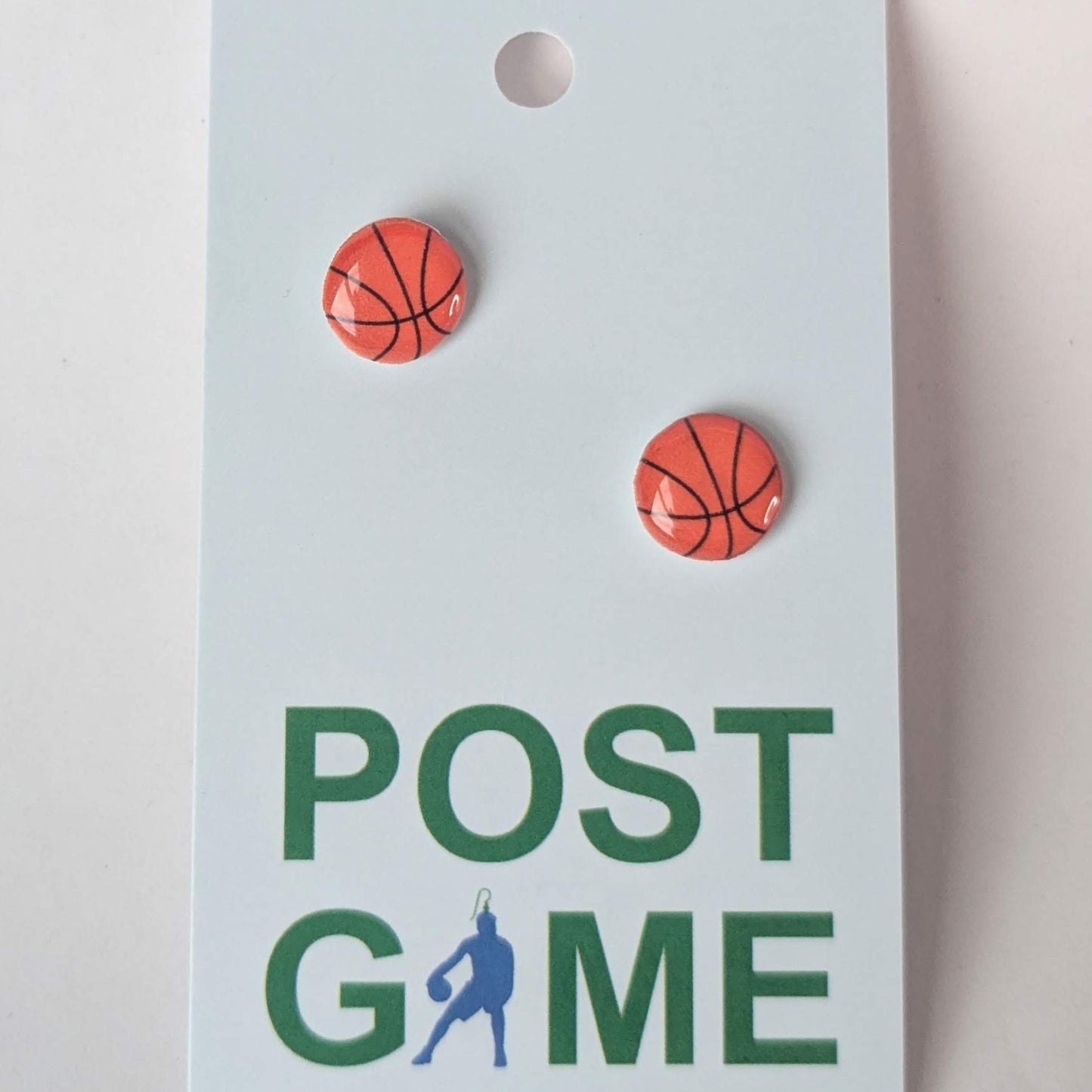 Basketball shaped earrings on a 'POST GAME' branded card with a light gray background