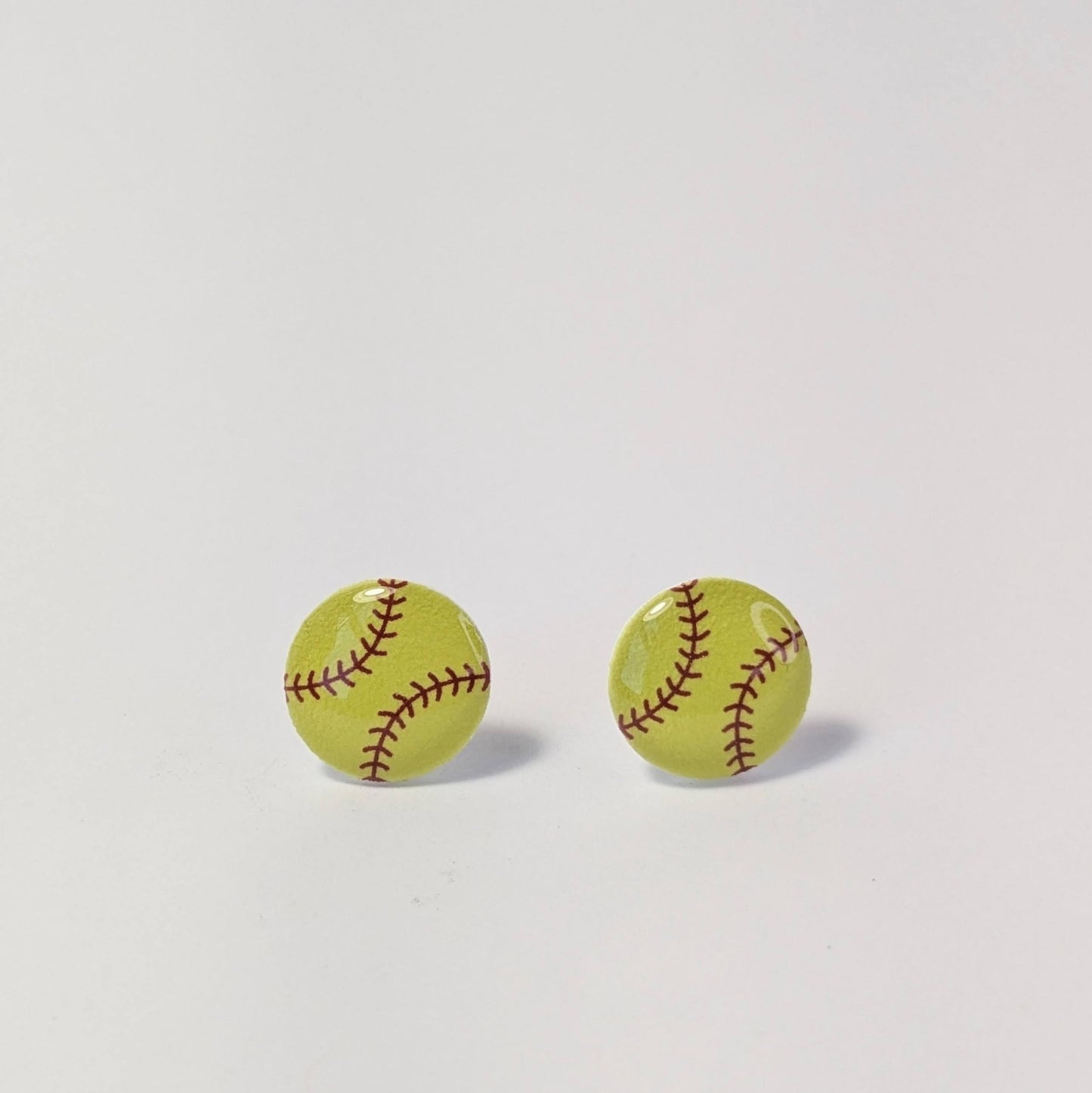 Yellow earrings with red stitching on a light gray background