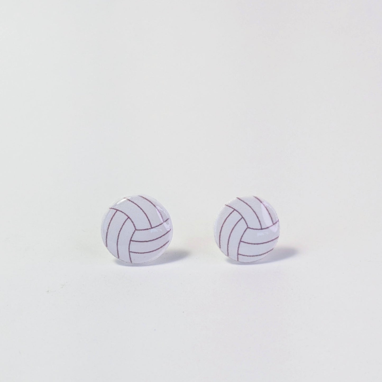 Pair of volleyball-shaped earrings on a light gray background