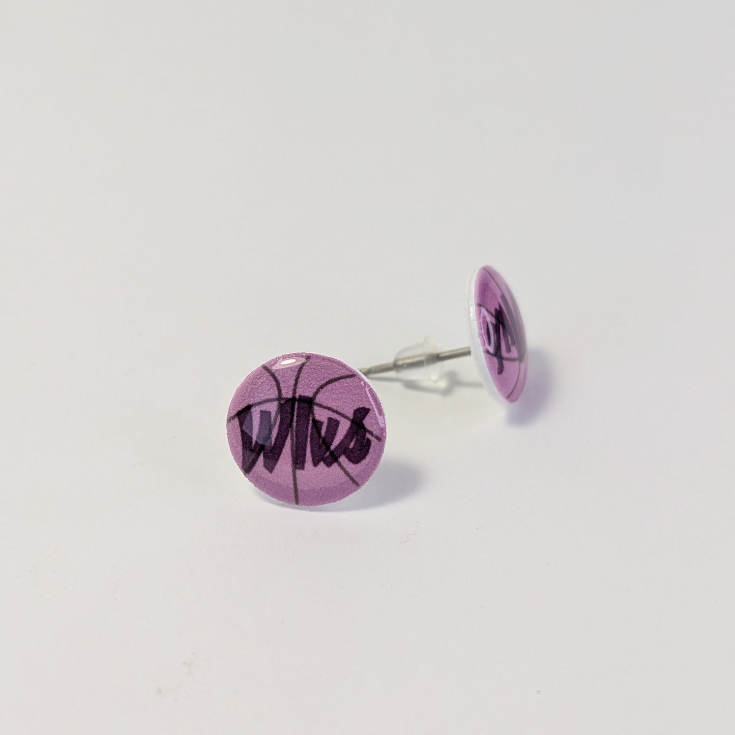 Purple earrings with 'Wlvs' text on a light gray background