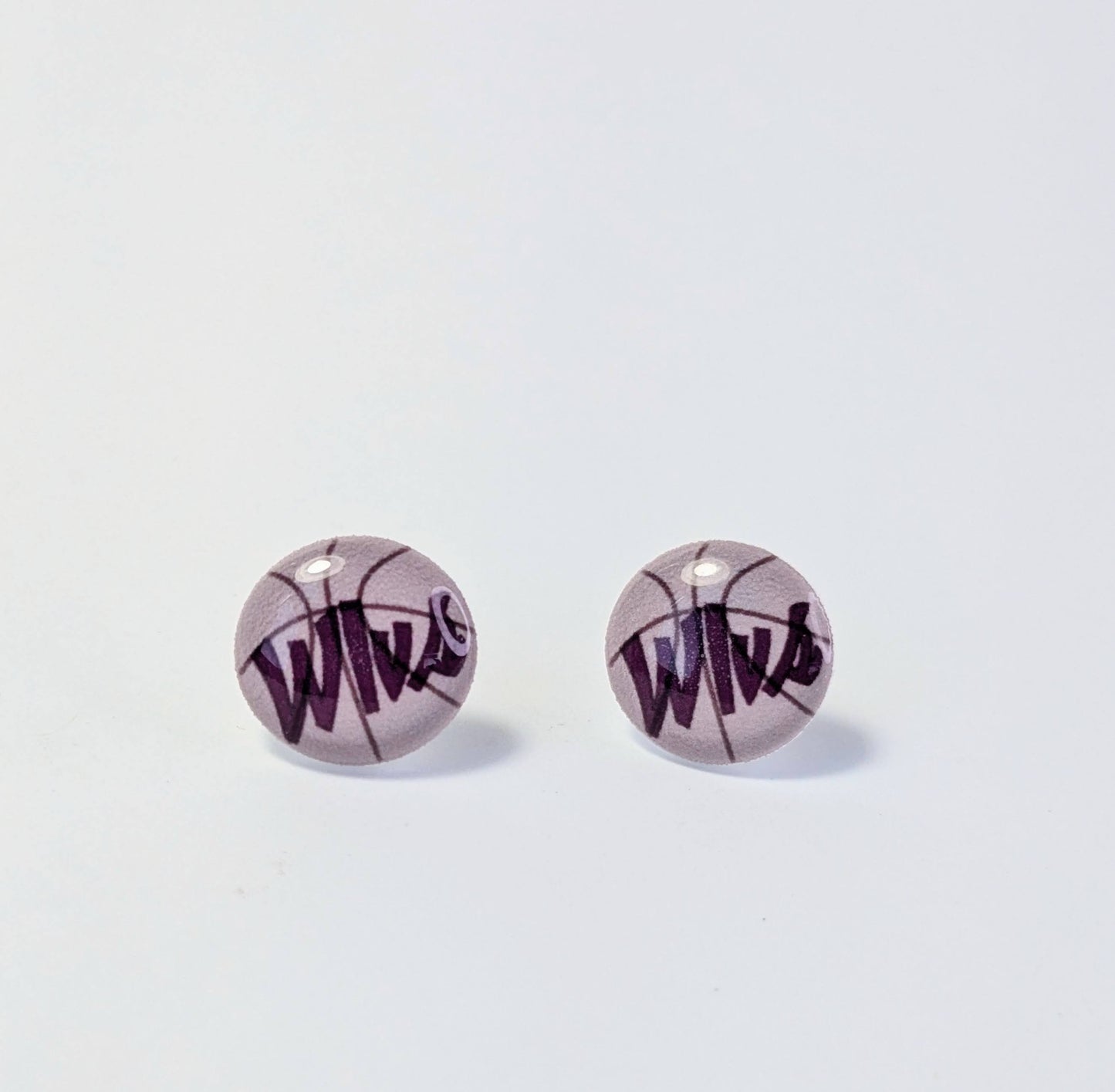 Basketball-shaped earrings with 'Wlvs" text on a light gray background