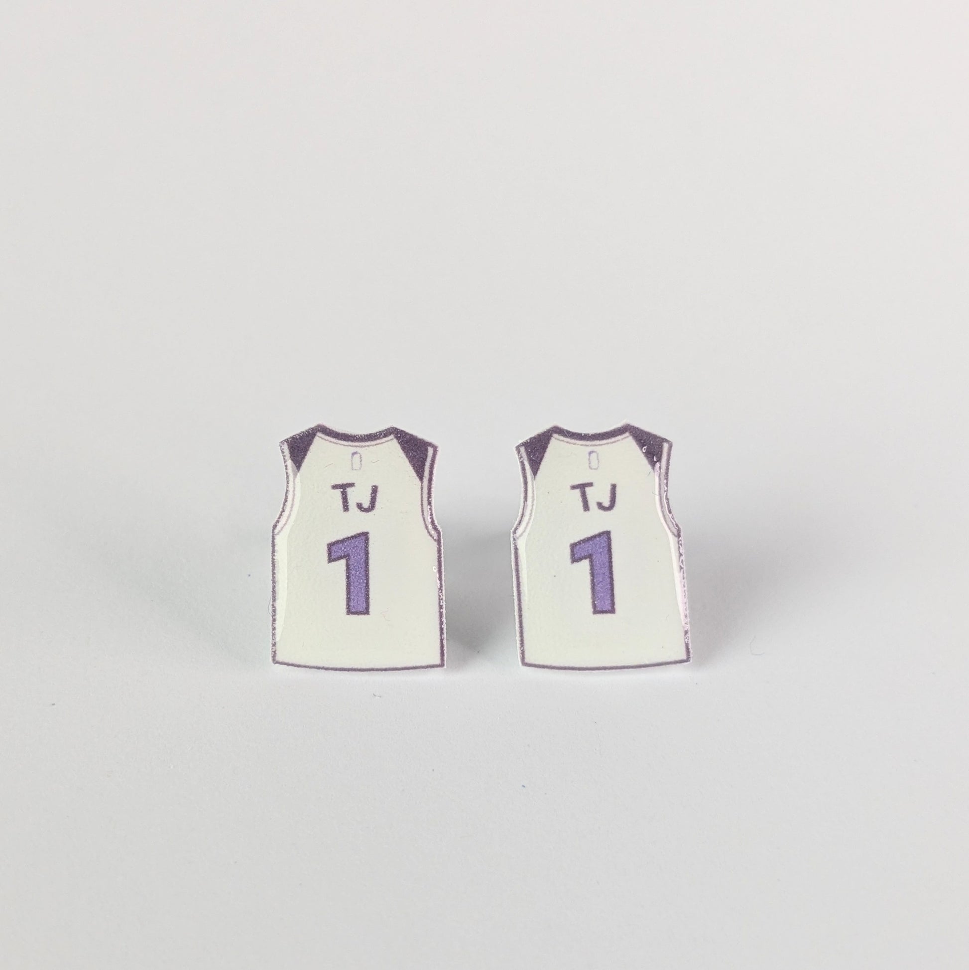 Two miniature basketball jerseys with 'TJ' and number '1' on a light gray background