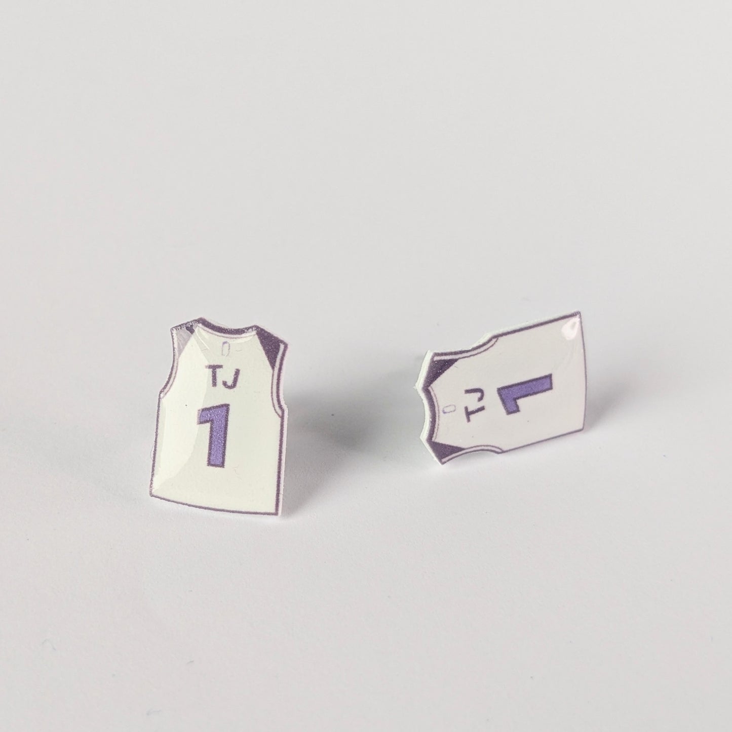 Two mini jersey earrings on a light gray background