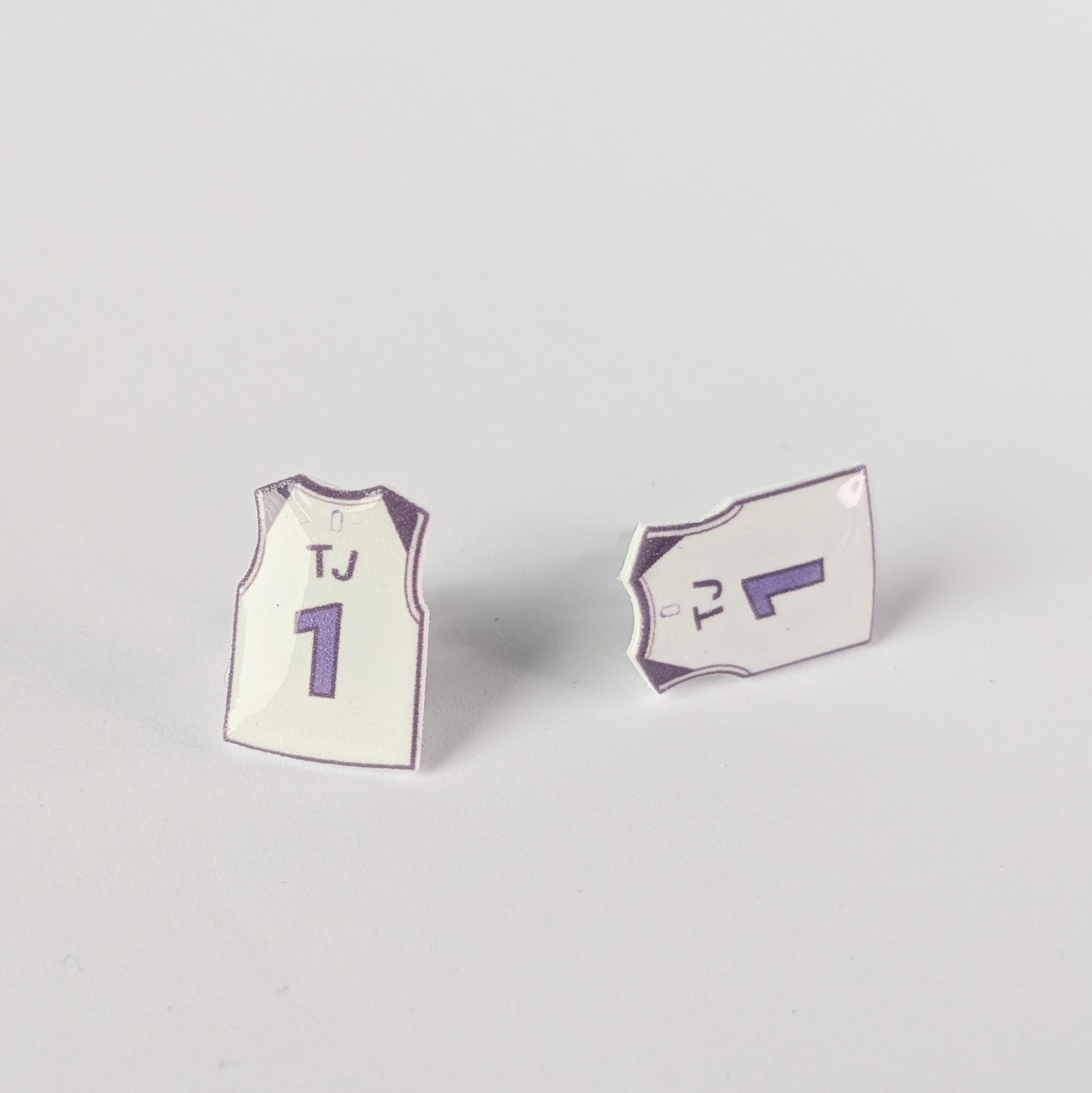 Two mini jersey earrings on a light gray background