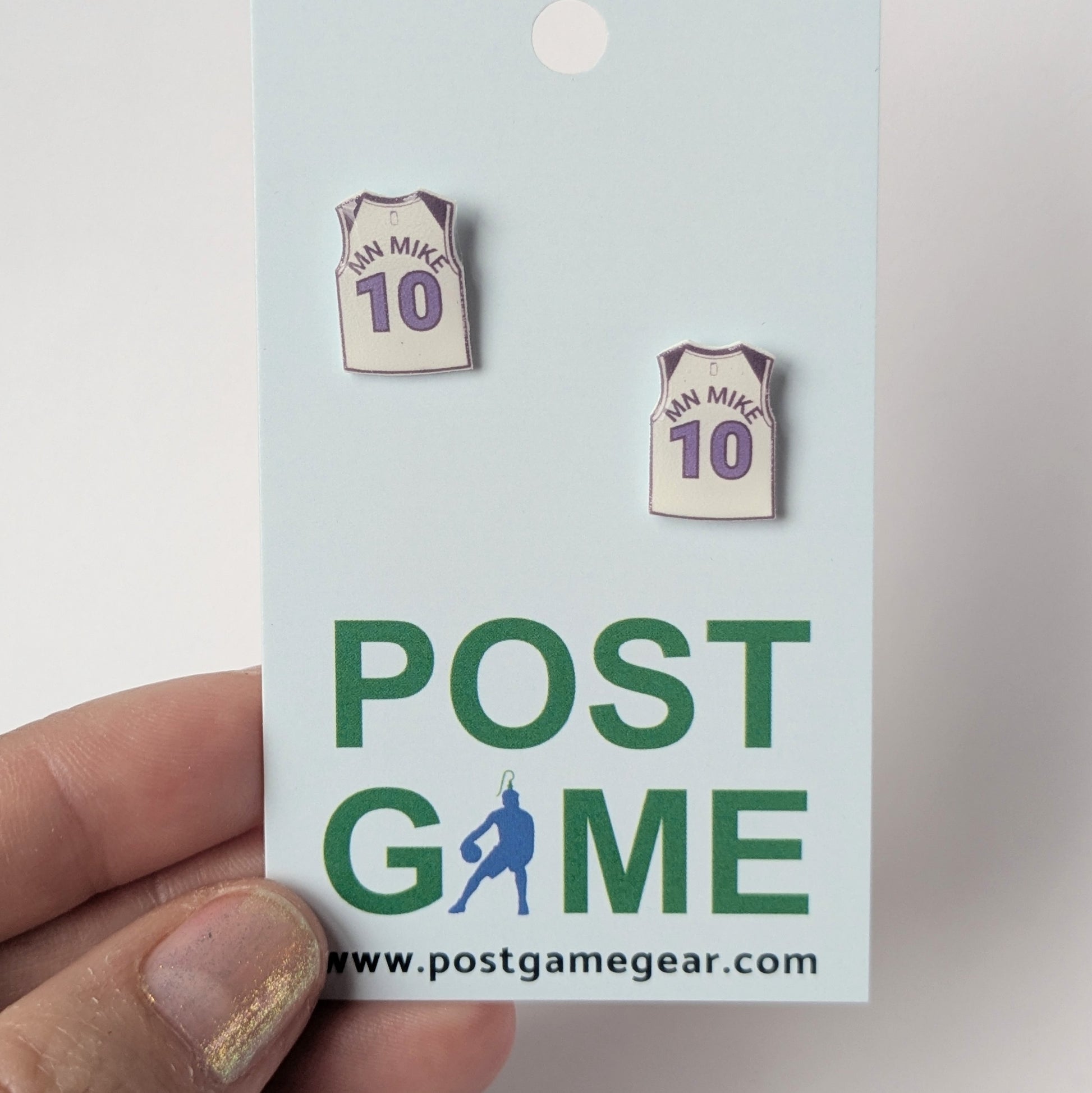 Pair of earrings shaped like basketball jerseys on a 'POST GAME' card.