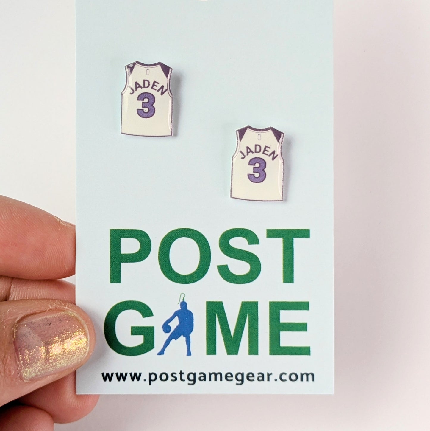 Two small basketball jersey earrings on a 'POST GAME' card
