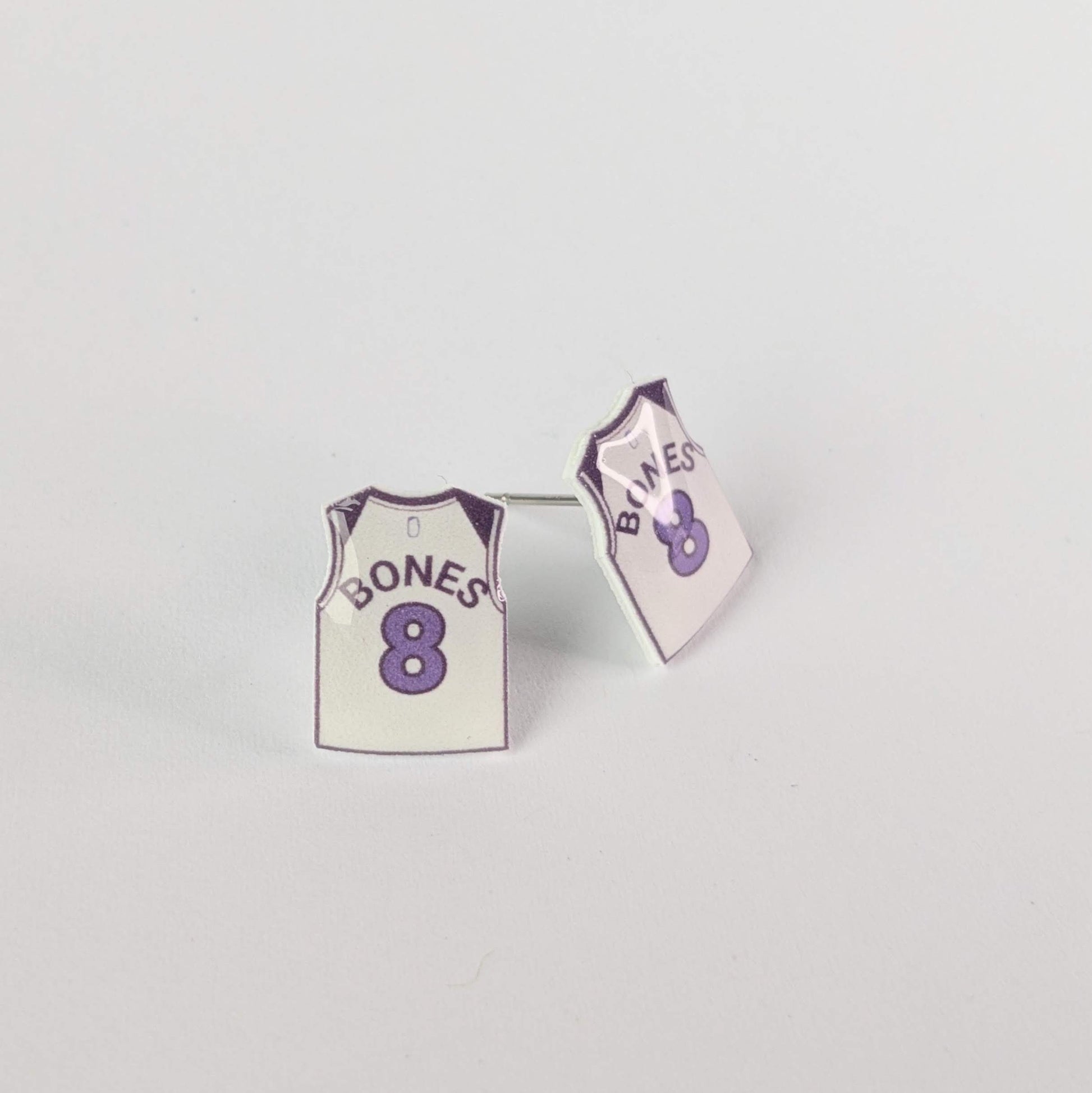 Mini jersey earrings with 'Bones' and '8' in text on a light background.